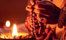 Devotee performing Shravan Pujas with a diya and prayer beads
